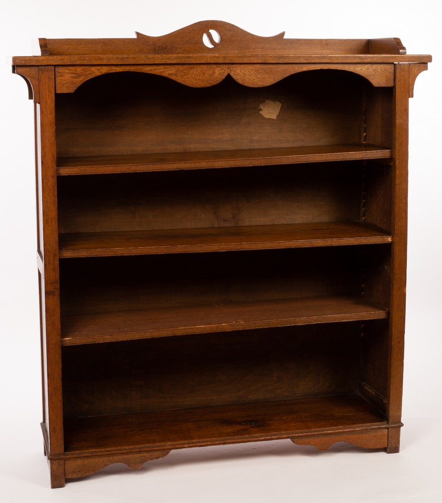 An Arts & Crafts style oak bookcase with pierced cresting above four shelves,