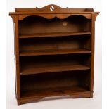An Arts & Crafts style oak bookcase with pierced cresting above four shelves,
