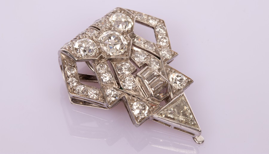 An Art Deco diamond clip of stylised triangular shape,