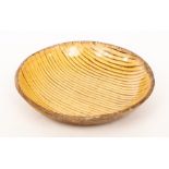 A Staffordshire slipware dish with trailed brown glaze on an ochre ground,