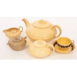 Two Wedgwood caneware teapots, the covers with corn sheaf finials, a similar jug,