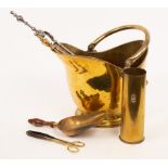 A brass helmet-shaped coal scuttle with swing handle,