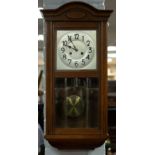 An Edwardian wall clock with silvered dial,