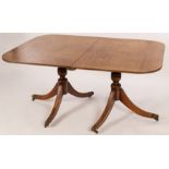 A George III mahogany twin-pedestal dining table, each pedestal of tripod form,