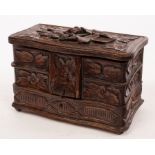 A carved oak jewel box with fitted interior, containing a lava cameo brooch,