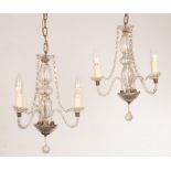 A pair of cut glass three-light chandeliers with spiral branches hung trails of prismatic drops and