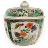 A Chinese famille verte deep bowl and cover, Kangxi, decorated panels of flowers and insects,