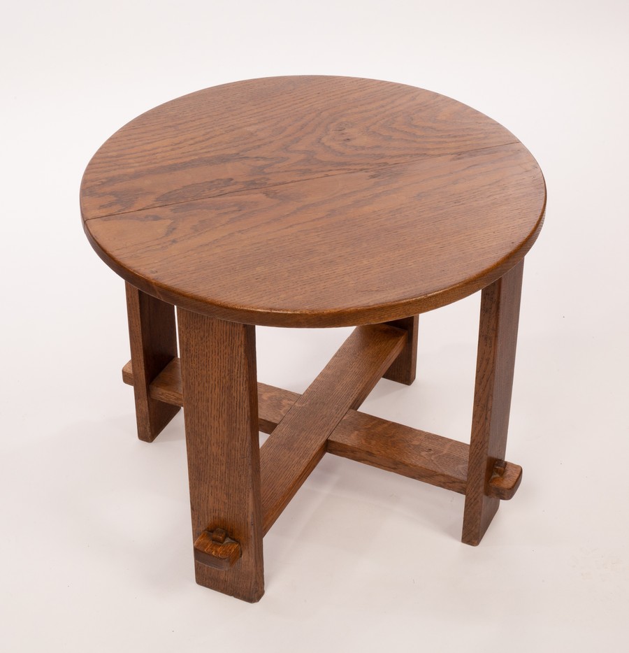 An Arts & Crafts style oak table, the circular top on plain legs joined by an X stretcher,