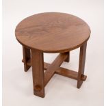 An Arts & Crafts style oak table, the circular top on plain legs joined by an X stretcher,