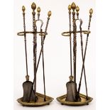 A fine pair of burnished steel brass mounted fire iron stands with baluster turned supports and