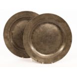 A pair of pewter chargers with folded rims, both initialled S over DE, 37.