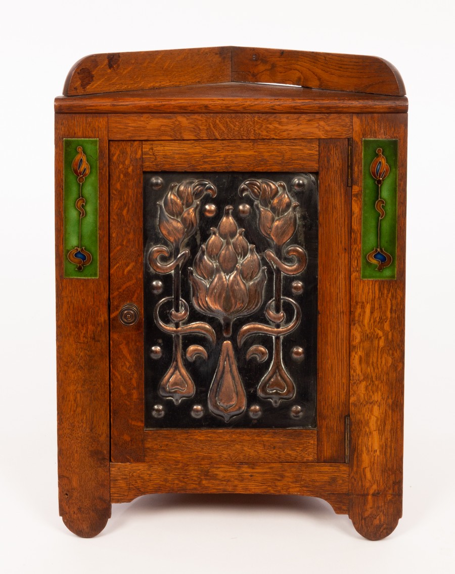 An Art Nouveau oak, copper and enamel smokers corner cabinet,