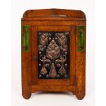 An Art Nouveau oak, copper and enamel smokers corner cabinet,