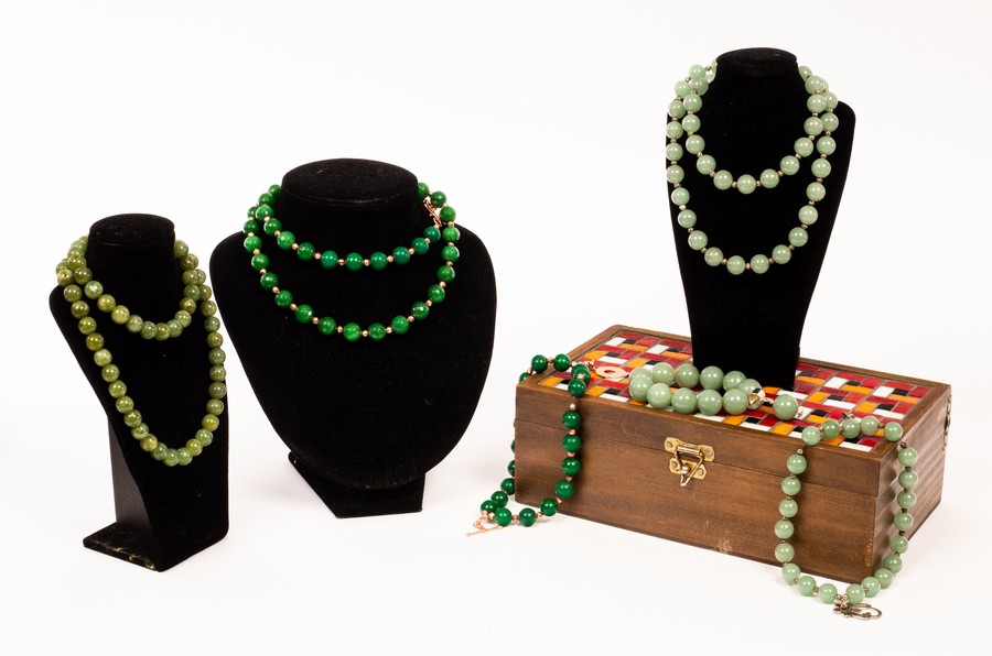 Various jadeite bead necklaces and bracelets in a wooden box with mosaic type cover