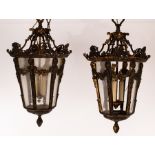 A pair of hexagonal tapering lanterns, the oxidised frames with swags to each panel,