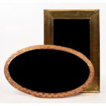 An oval copper framed mirror, 47cm x 80.5cm and a brass mirror of shaped oblong form, 38.