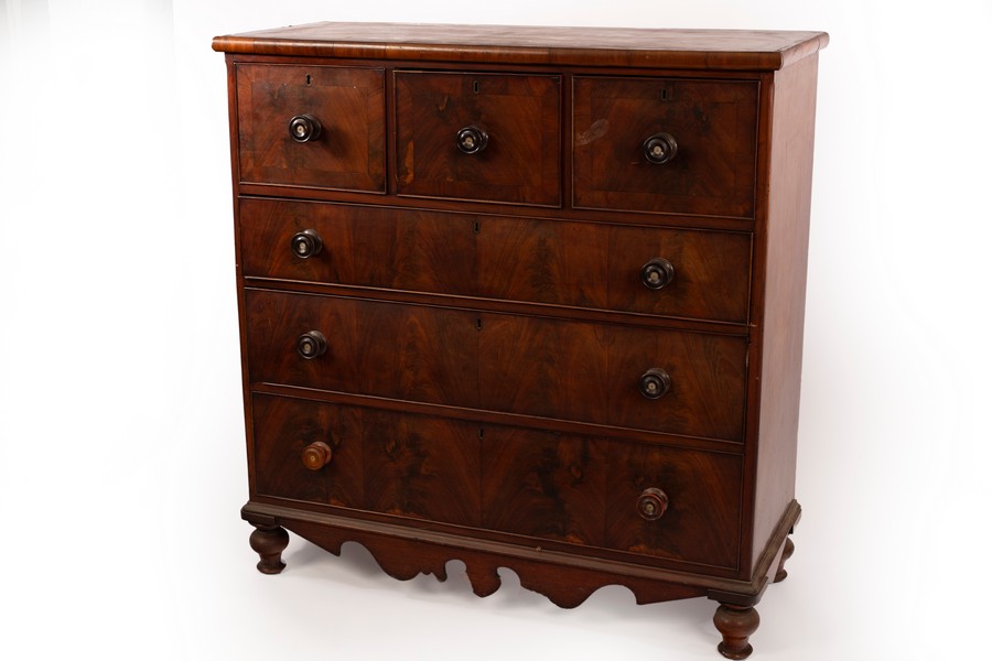 A Victorian mahogany chest of drawers with a shaped apron,