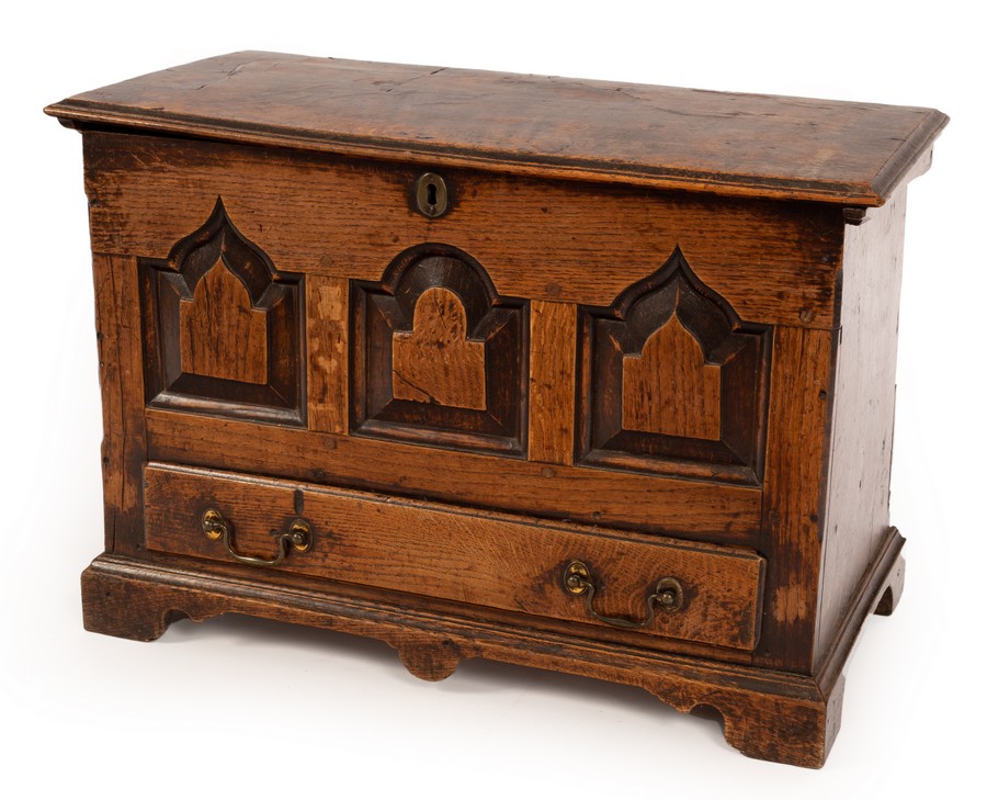 An early 18th Century oak coffer bach, the hinged cover with moulded border,