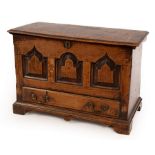 An early 18th Century oak coffer bach, the hinged cover with moulded border,