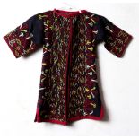 Afghan black child's robe decorated with latch hooks and ram's horns and floral medallions