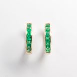 A pair of emerald and fourteen karat gold hoop earrings