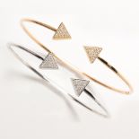A pair of white or yellow fourteen karat gold and diamond cuff bracelets
