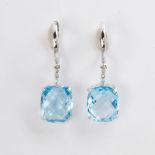 A pair of blue topaz, diamond and fourteen karat white gold earrings