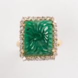 A carved emerald, diamond and eighteen karat gold ring