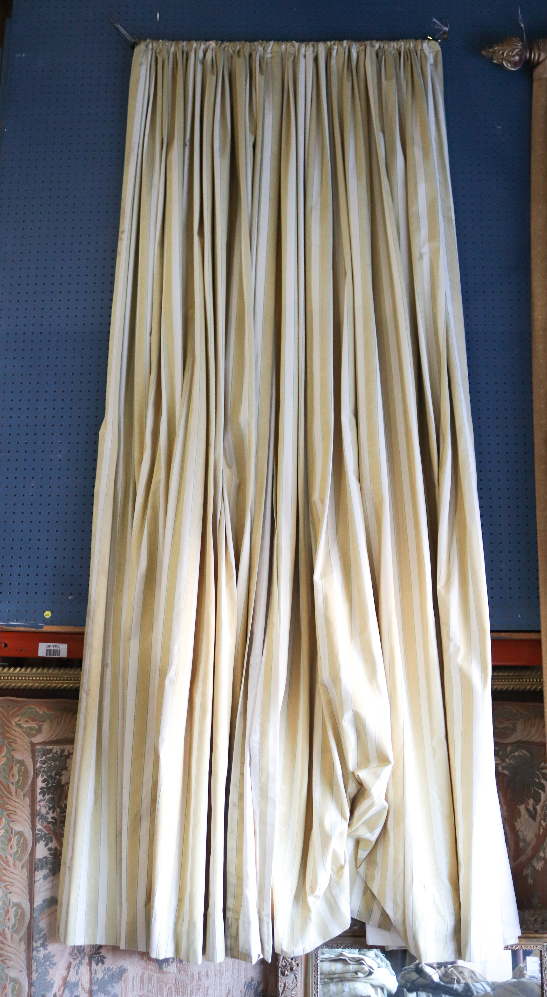 A set of drapes in striped upholstery, and tie-backs with tassels and additional hardware