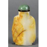 Chinese jadeite snuff bottle carved from a russet backed grey stone