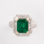 An emerald, diamond and eighteen karat white gold ring