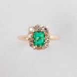 An emerald, diamond and fourteen karat gold ring