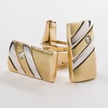 A pair of diamond and fourteen karat bi-color gold cufflinks