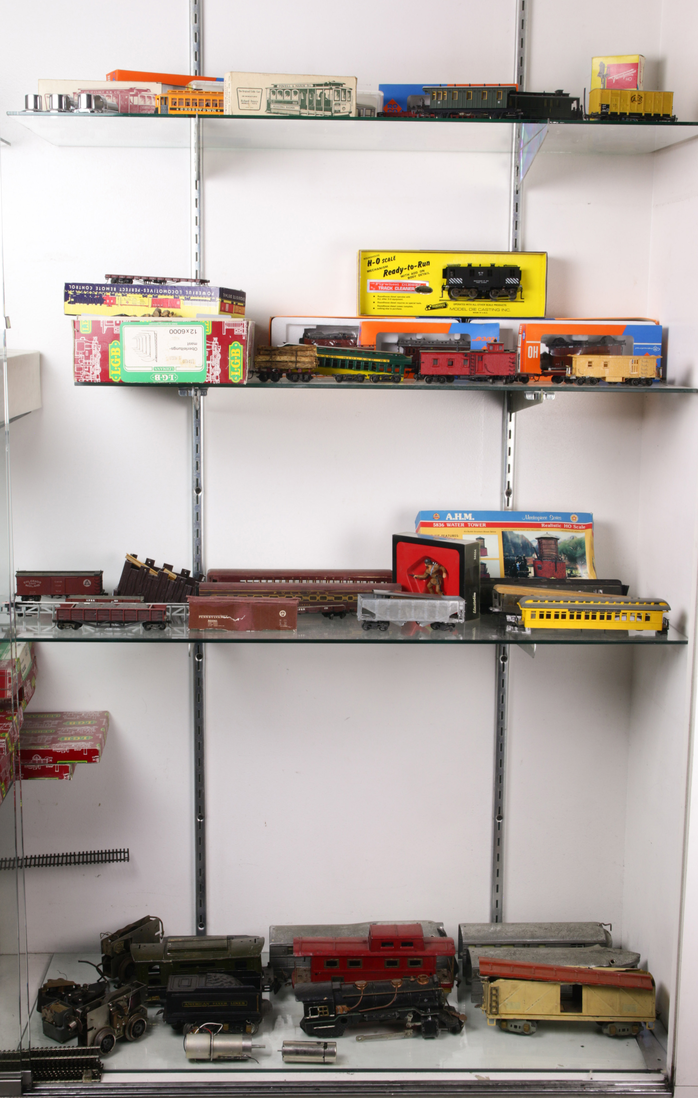 Five shelves of mainly H-O scale trains including engines