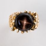A black star sapphire and fourteen karat gold ring