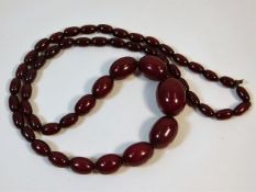 A vintage set of graduated cherry amber style beaded necklace, 29in long 60.7g, largest bead 29.3mm