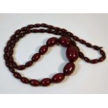 A vintage set of graduated cherry amber style beaded necklace, 29in long 60.7g, largest bead 29.3mm