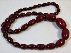 A vintage set of graduated cherry amber style beaded necklace, 23in long 48g, largest bead 27.2mm x