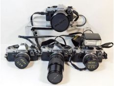 Four 35mm film cameras by Olympus OM10 cameras wit