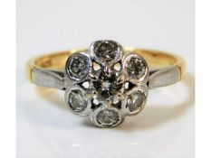 A two colour 18ct gold daisy style ring set with s