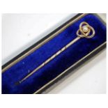 An antique yellow metal tie pin, electronically tests as 10ct gold, with knot & pearl decor, 56.8mm