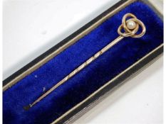 An antique yellow metal tie pin, electronically tests as 10ct gold, with knot & pearl decor, 56.8mm