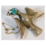 An antique white metal memorial brooch depicting a dove set with natural turquoise, 11.1g