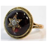 A 19thC. yellow metal ring, shank electronically tests as 10ct gold, set with cabouchon cut garnet &