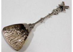 An ornate 0.900 silver spoon with windmill finial