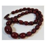 A vintage set of graduated cherry amber style beaded necklace, 21.5in long 63.3g, largest bead 26.9m