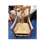 An early 20thC. oak throne style chair with rush s