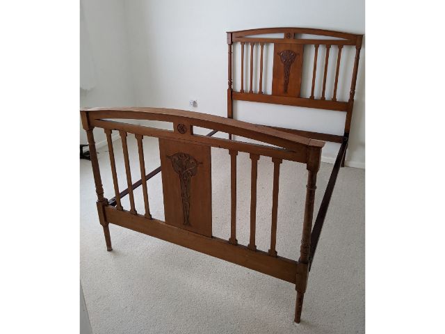 An Edwardian walnut double bed with carved decor