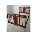 An Edwardian walnut double bed with carved decor