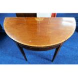 A Regency period D shaped card table on tapered le